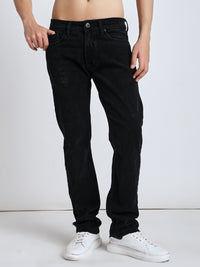 man wearing black jeans and white sneakers on a plain background