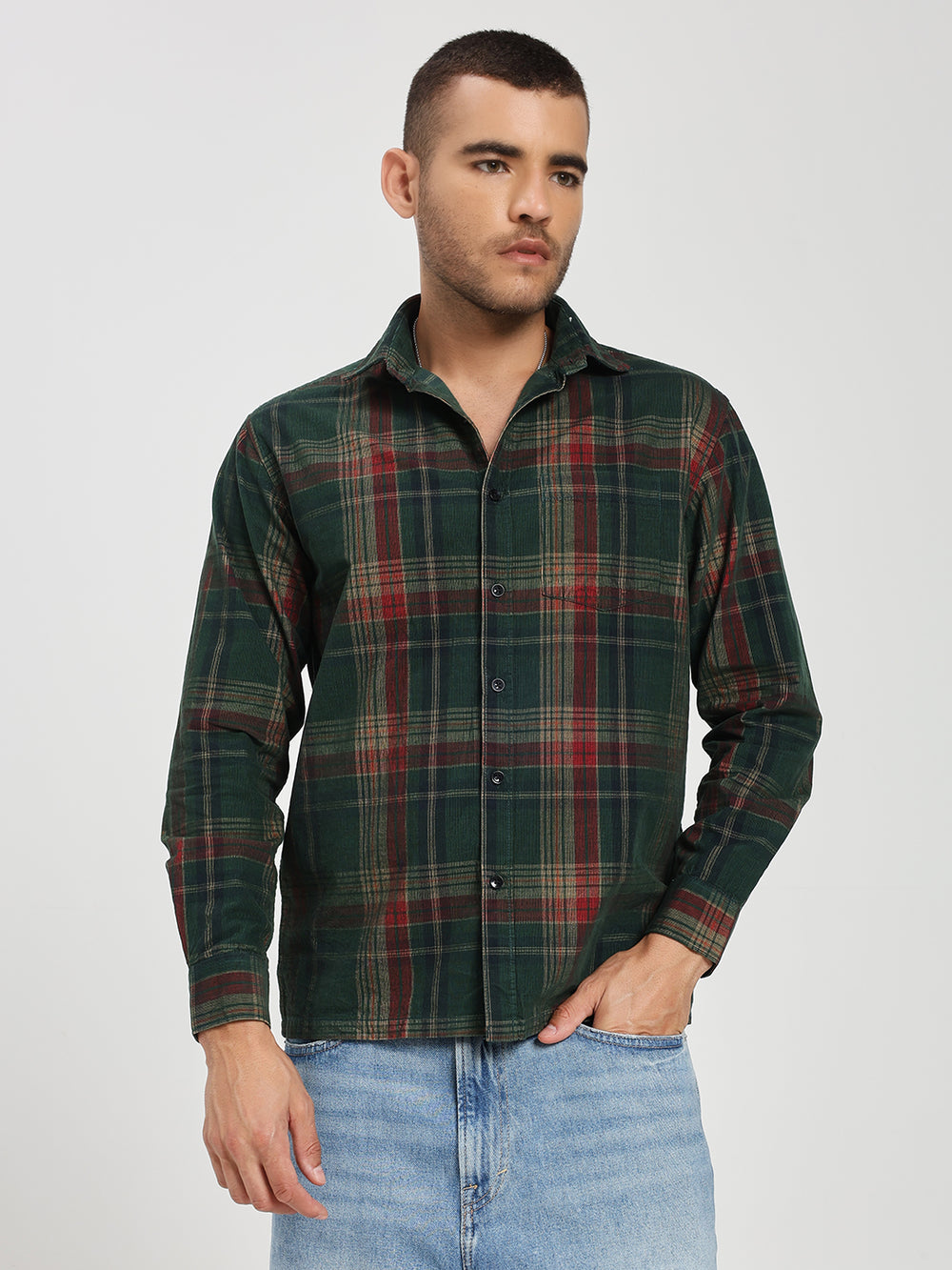 Man wearing a green plaid shirt and jeans on a white background