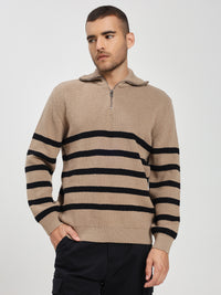 Man wearing a beige sweater with black stripes on a plain background