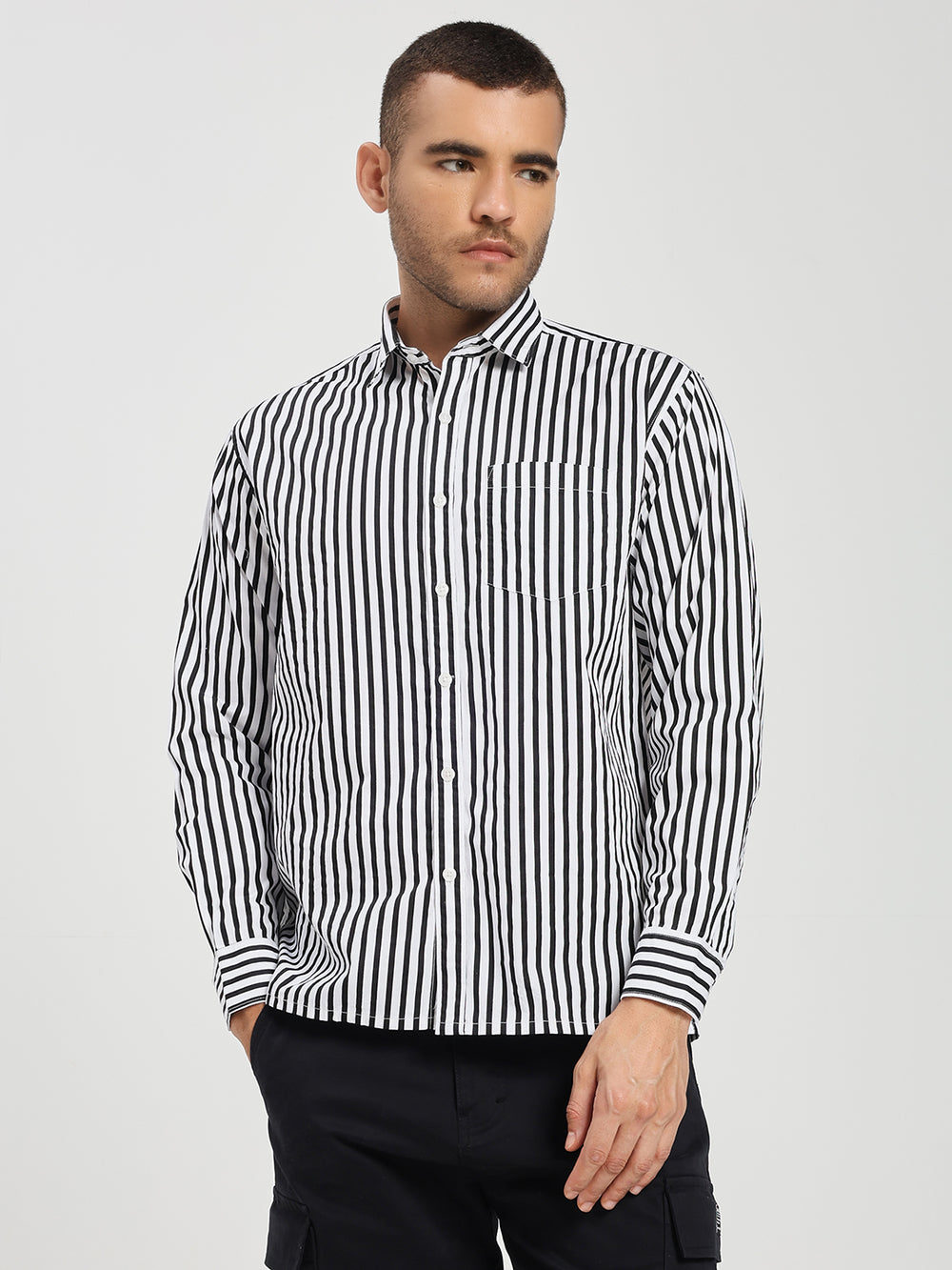 Man wearing a black and white striped shirt against a plain background