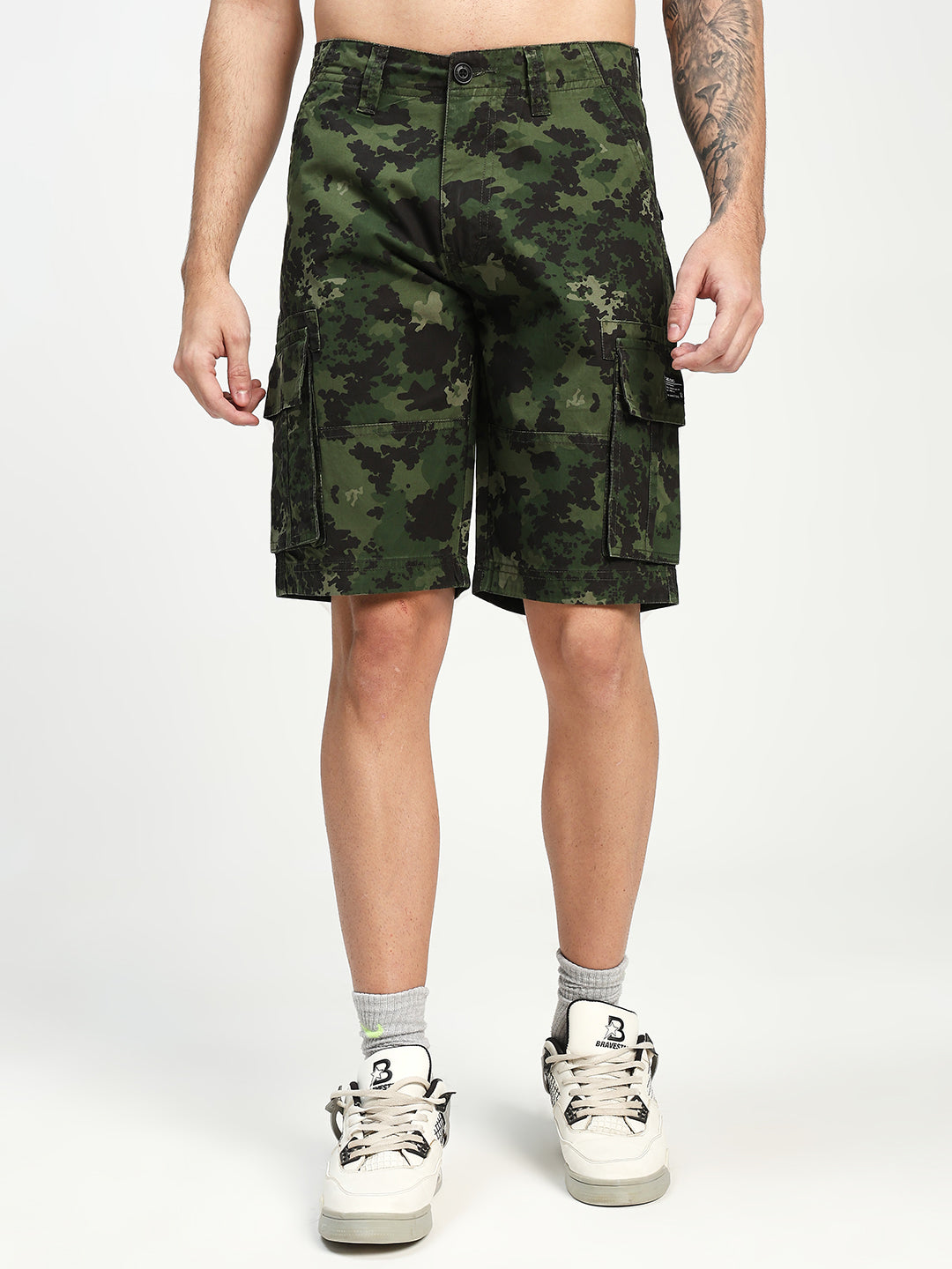 man wearing camouflage cargo shorts on a white background