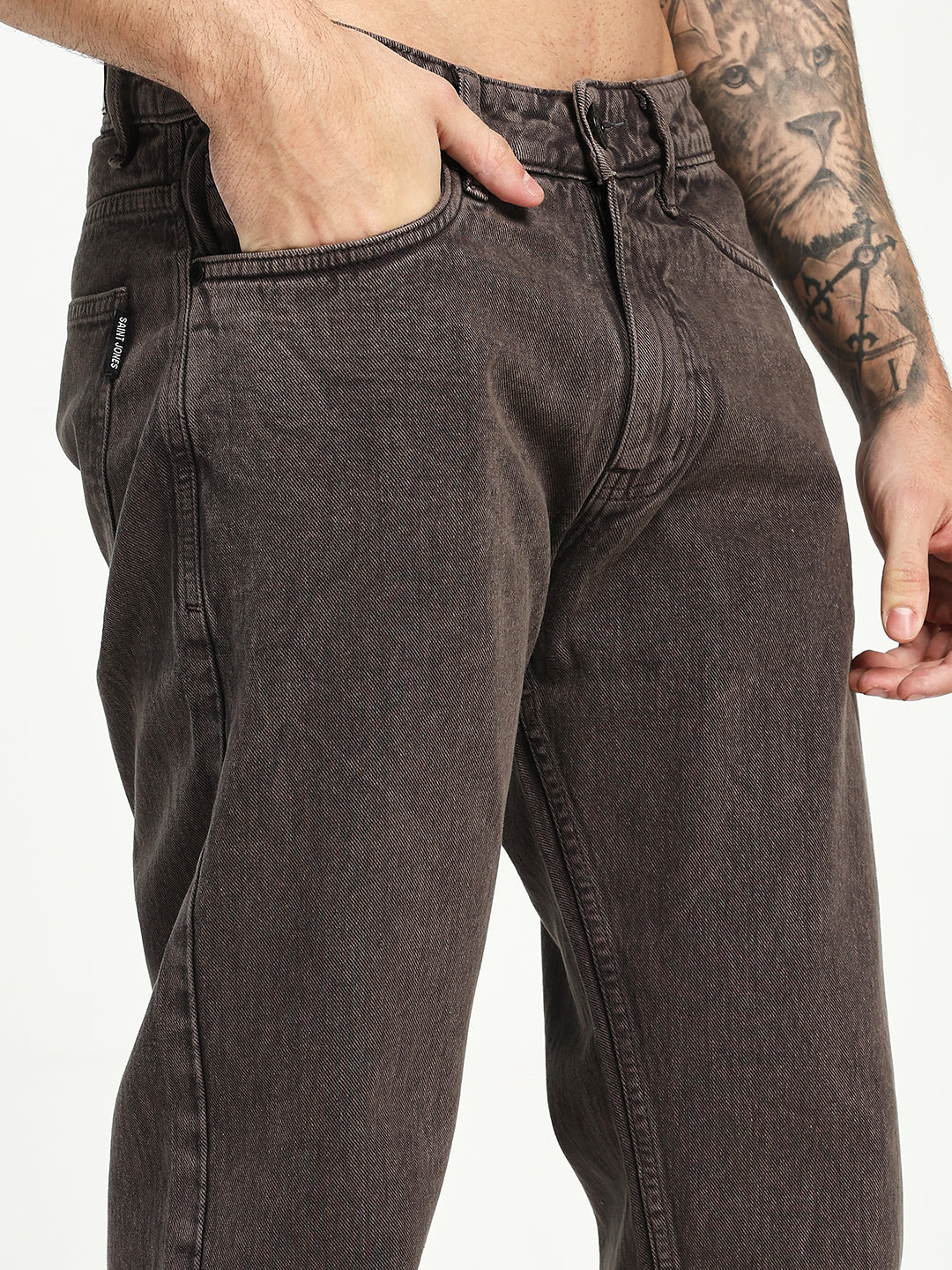 Dark brown ecru jeans worn by a man on a plain background