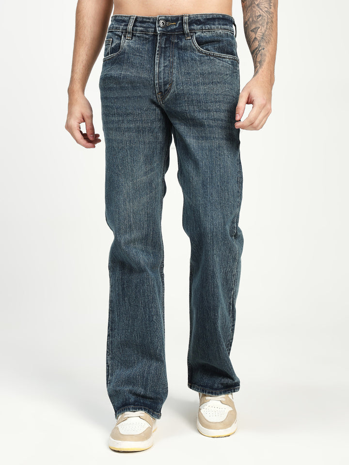 man wearing dark blue bootcut jeans on a white background