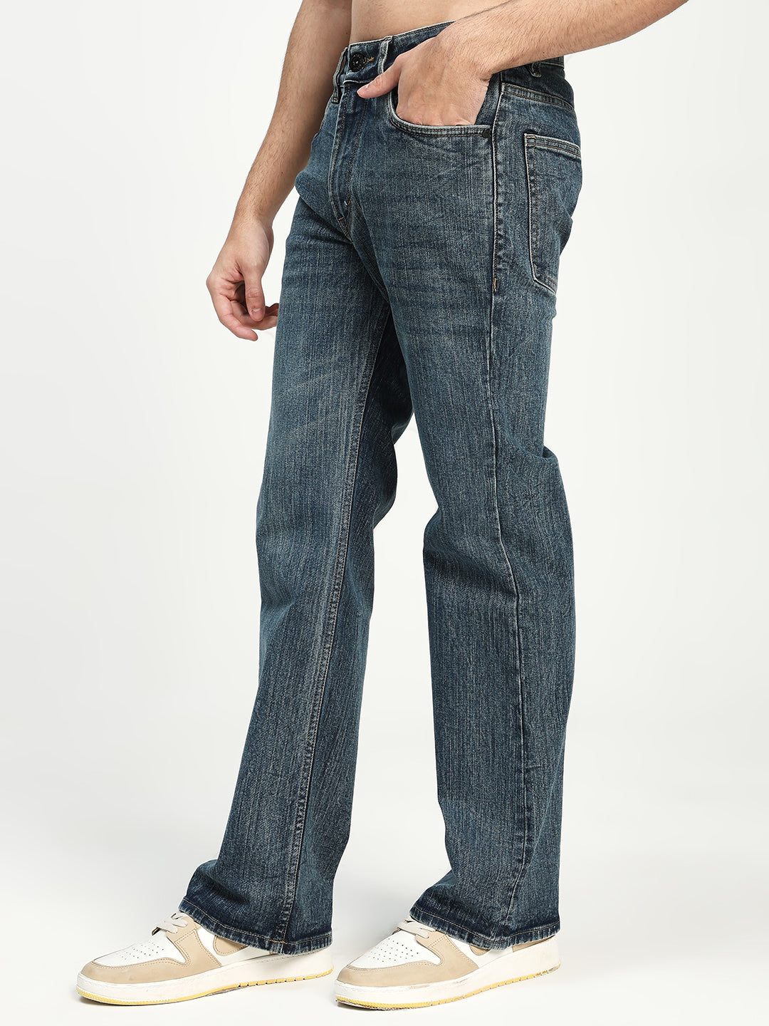 man wearing dark blue bootcut jeans on a white background