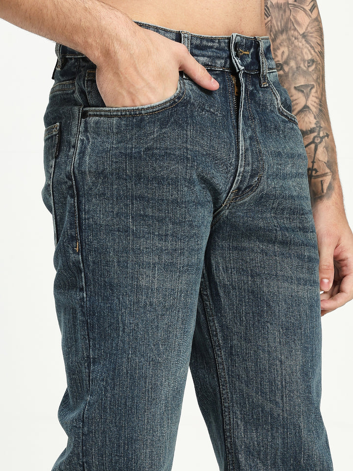 man wearing dark blue bootcut jeans on a white background