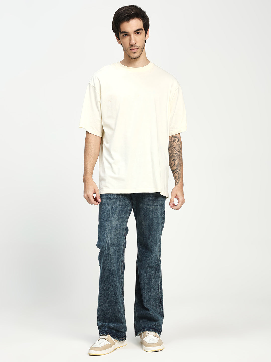 man wearing dark blue bootcut jeans on a white background