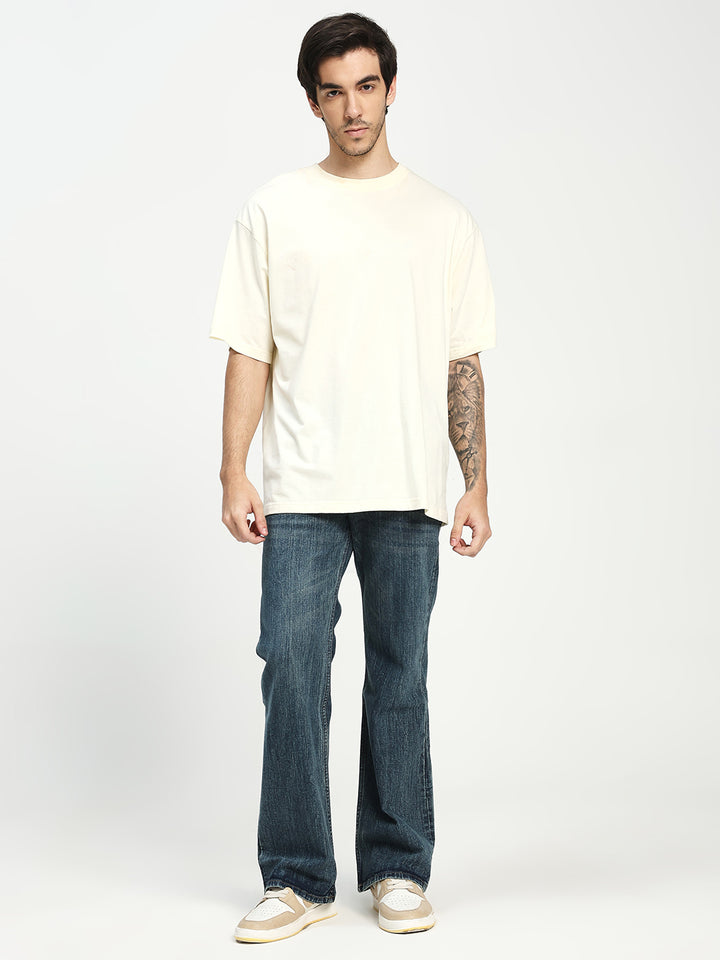man wearing dark blue bootcut jeans on a white background