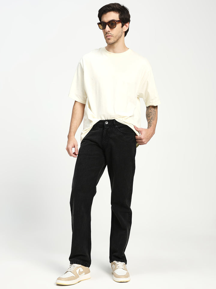 Man wearing a white t-shirt and black ecru jeans on a white background