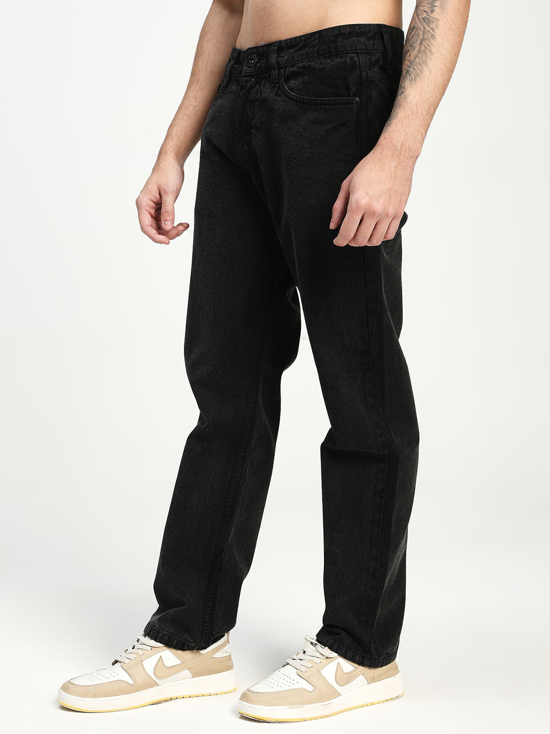 man wearing black ecru jeans on white background 