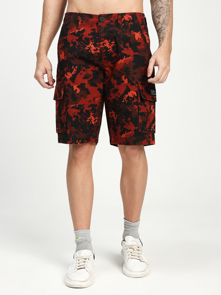 man wearing red and black camouflage cargo shorts on a white background