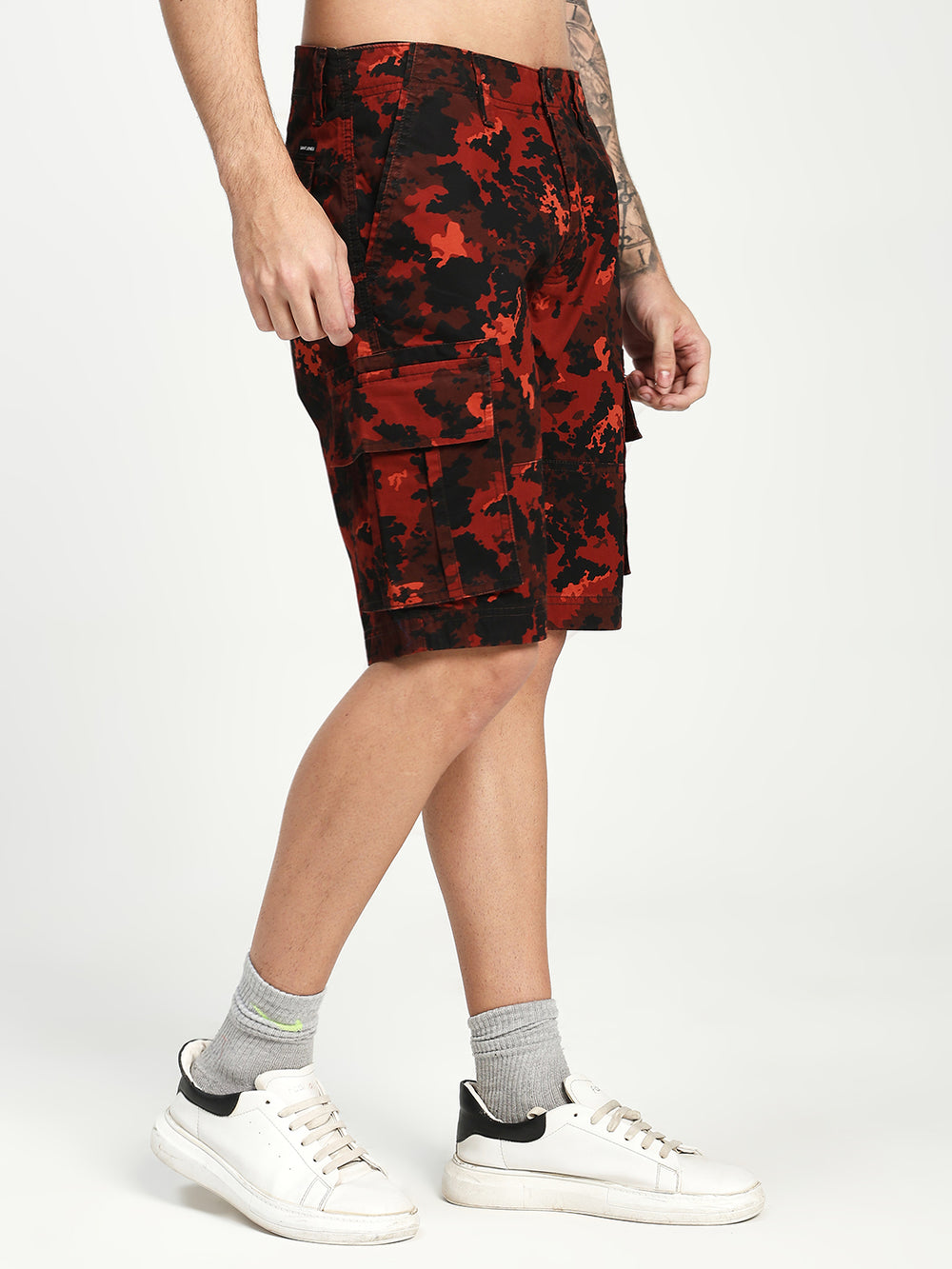 man wearing red and black camouflage cargo shorts on a white background