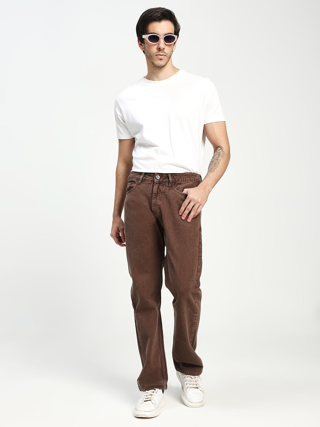 Man wearing a white t-shirt and brown ecru pants on a white background