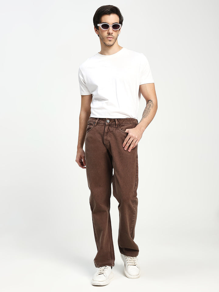 Man wearing a white t-shirt and brown ecru pants on a white background
