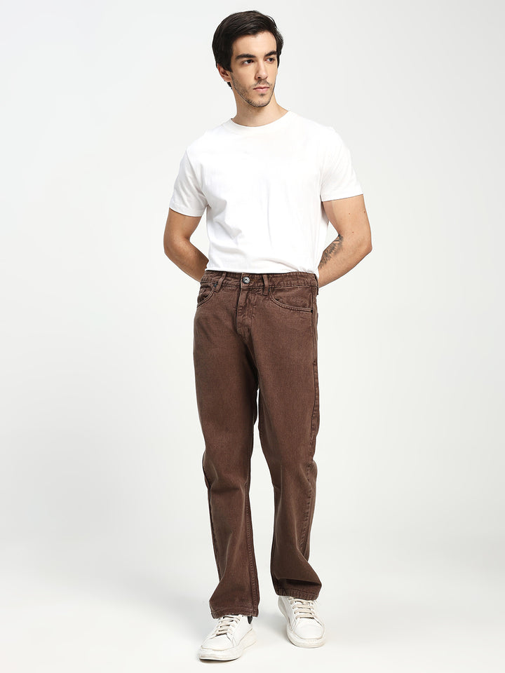 Man wearing a white t-shirt and brown ecru jeans on a white background