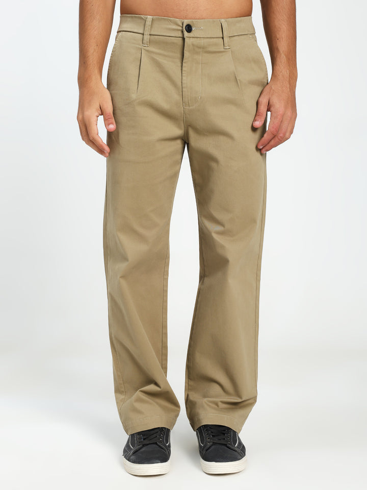 Beige korean pants worn by a man on a white background