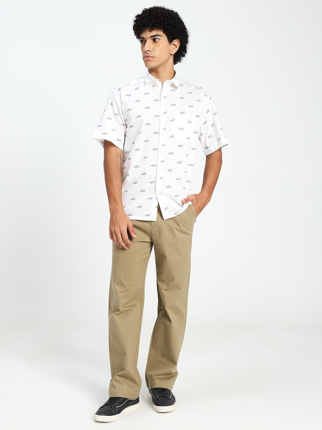 Man wearing a white patterned shirt and beige korean pants on a white background
