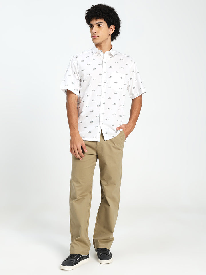 Man wearing a white patterned shirt and beige korean pants on a white background