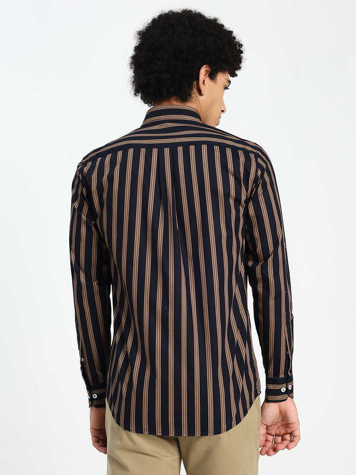 Man wearing a navy blue and brown striped shirt on a white background