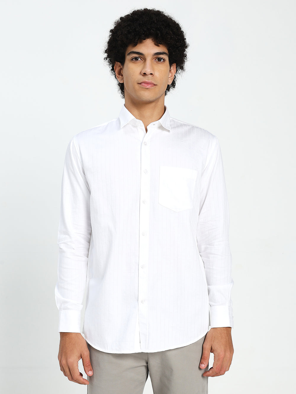 Man wearing a white shirt against a plain background