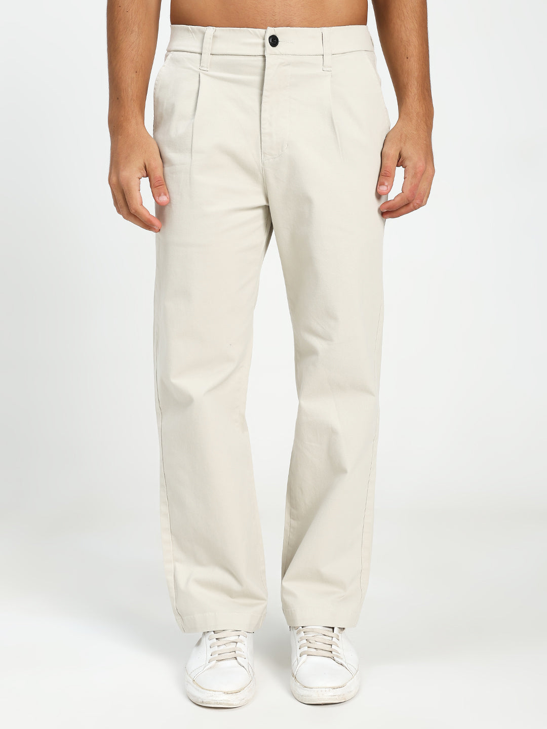 man wearing cream korean pants on a plain background