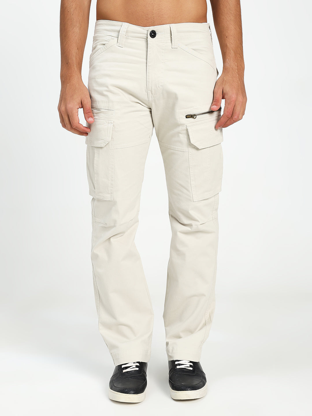 man wearing cream cargo pants on a white background