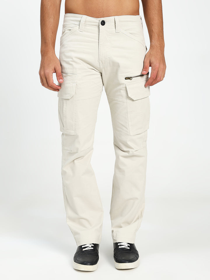 man wearing cream cargo pants on a white background