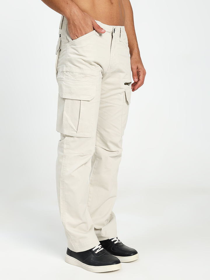 man wearing cream  cargo pants on a white background