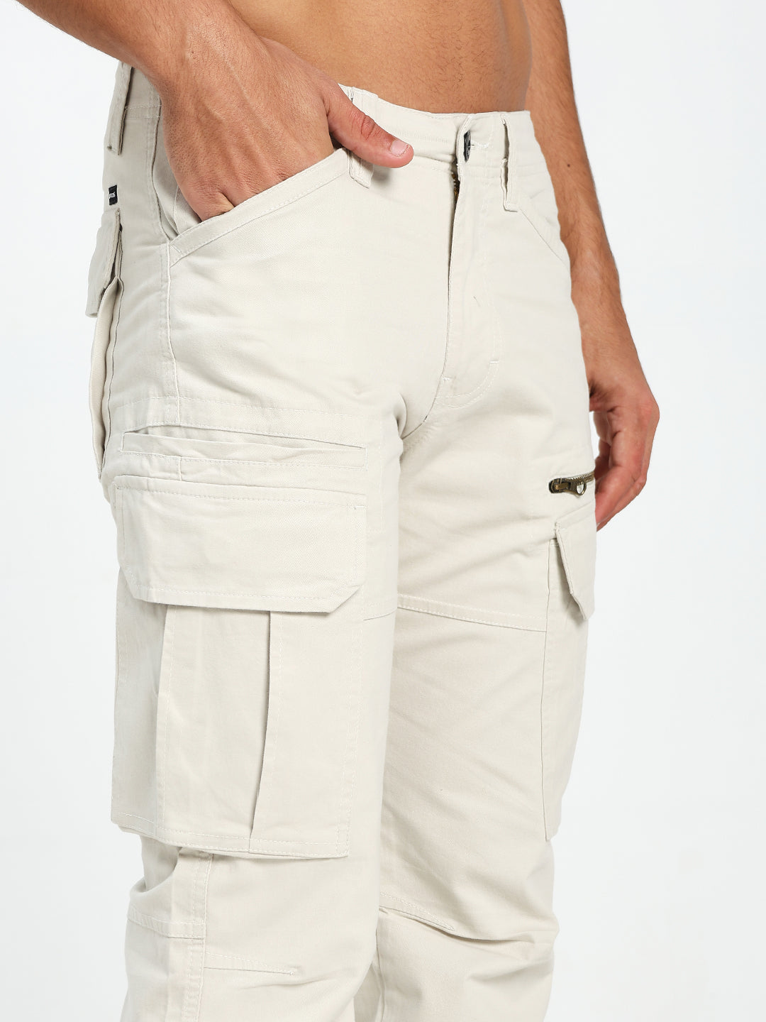 cream cargo pants worn by a man on a white background