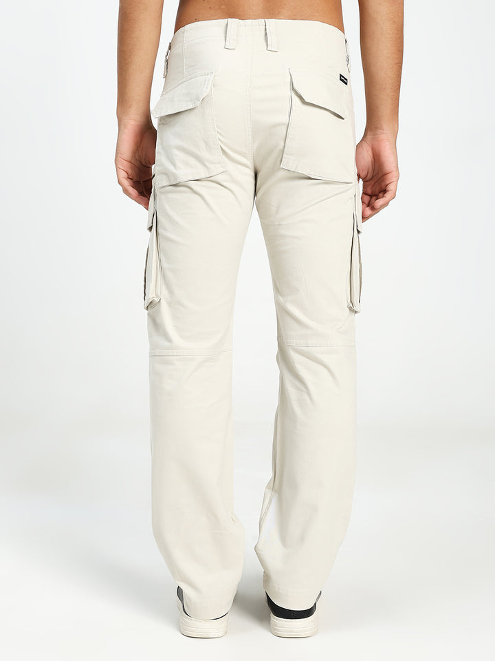 cream cargo pants worn by a person on a white background