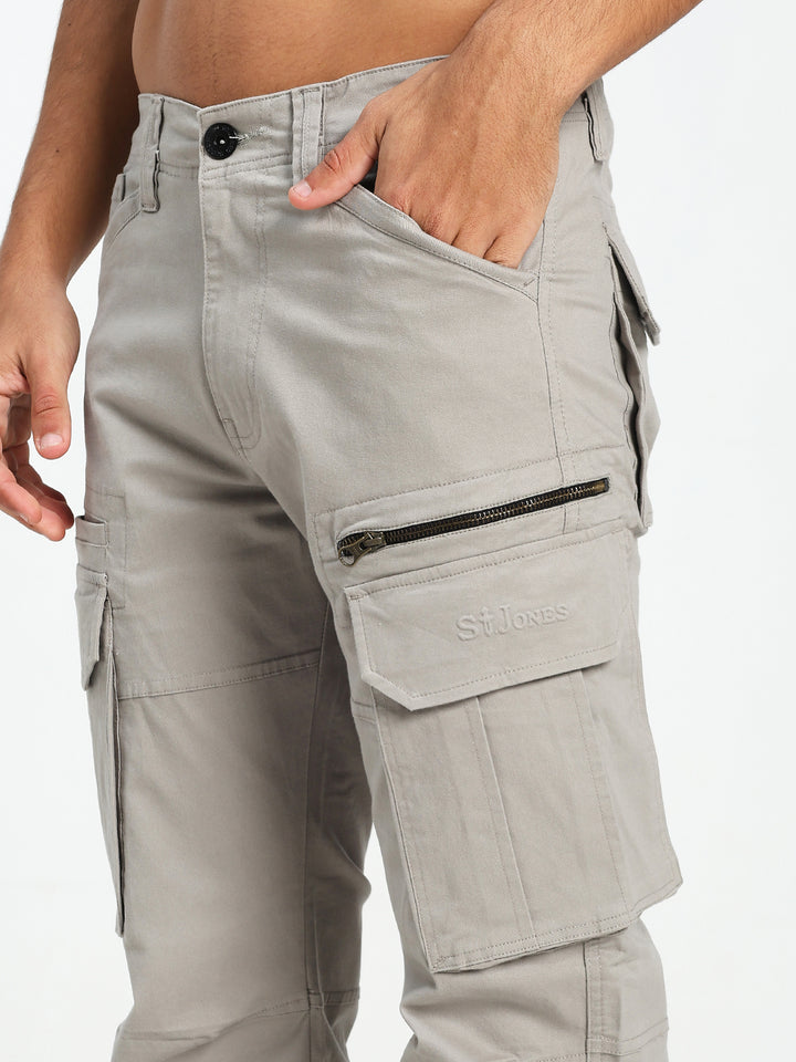Light gray cargo pants with multiple pockets and zippers on a white background