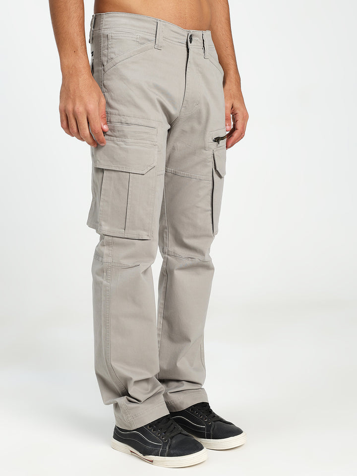 man wearing light gray cargo pants on a white background