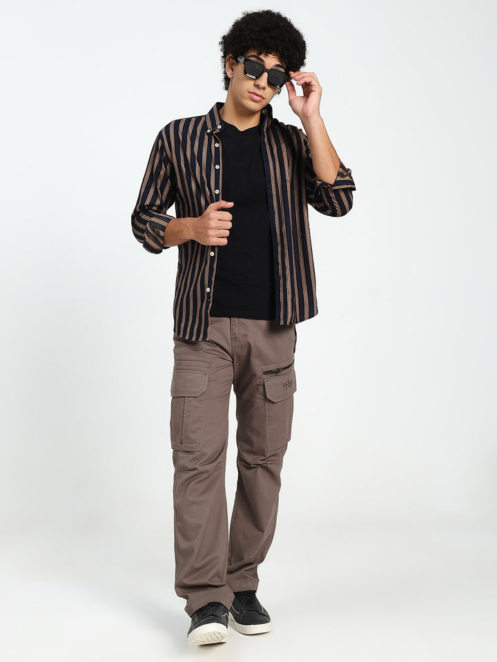 Man wearing a striped shirt, black t-shirt, and cargo pants on a white background