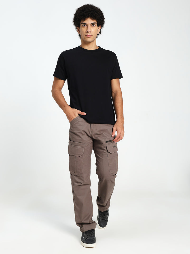 man wearing a black t-shirt and brown cargo pants on a white background