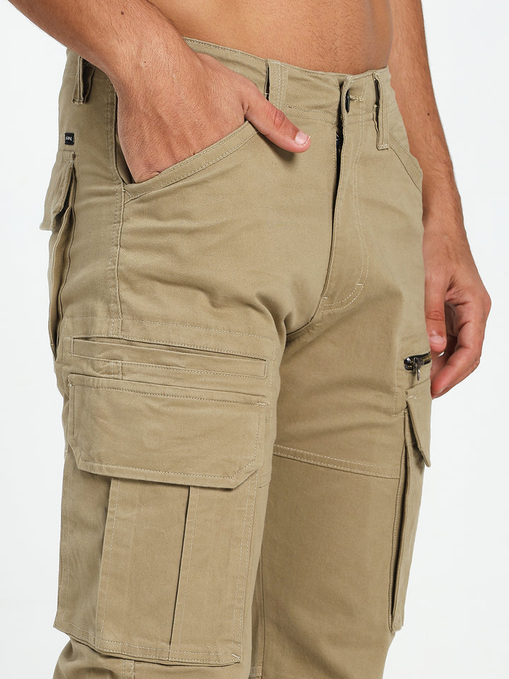 Beige cargo pant worn by a man on a white background
