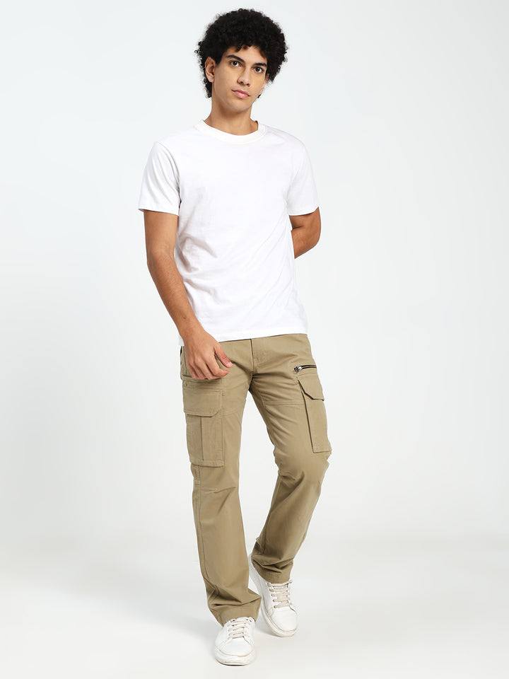Man wearing a white t-shirt and beige cargo pants on a white background