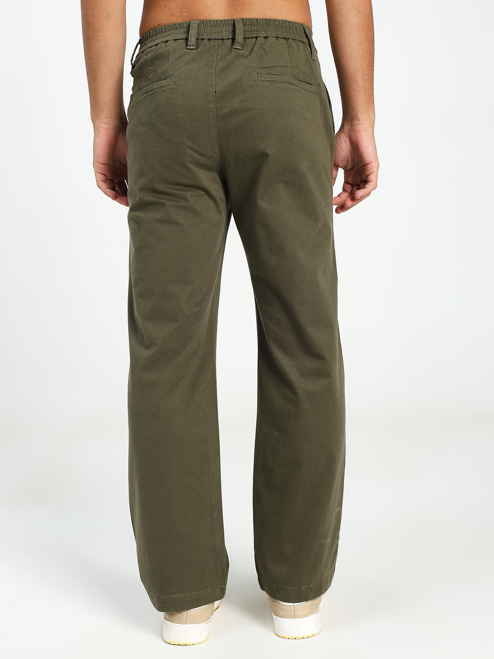 man wearing olive green korean pants on a white background