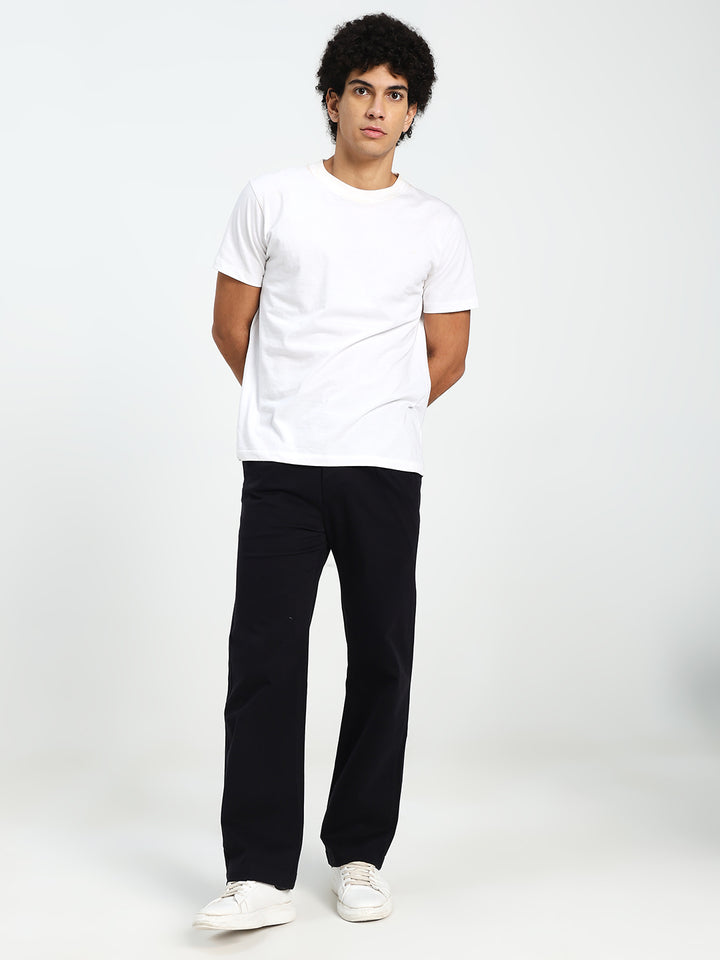 Man wearing a white t-shirt and black Korean pants on a white background