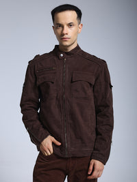 Man wearing a brown jacket against a gray background