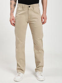 man  wearing beige chinos pants on a white background