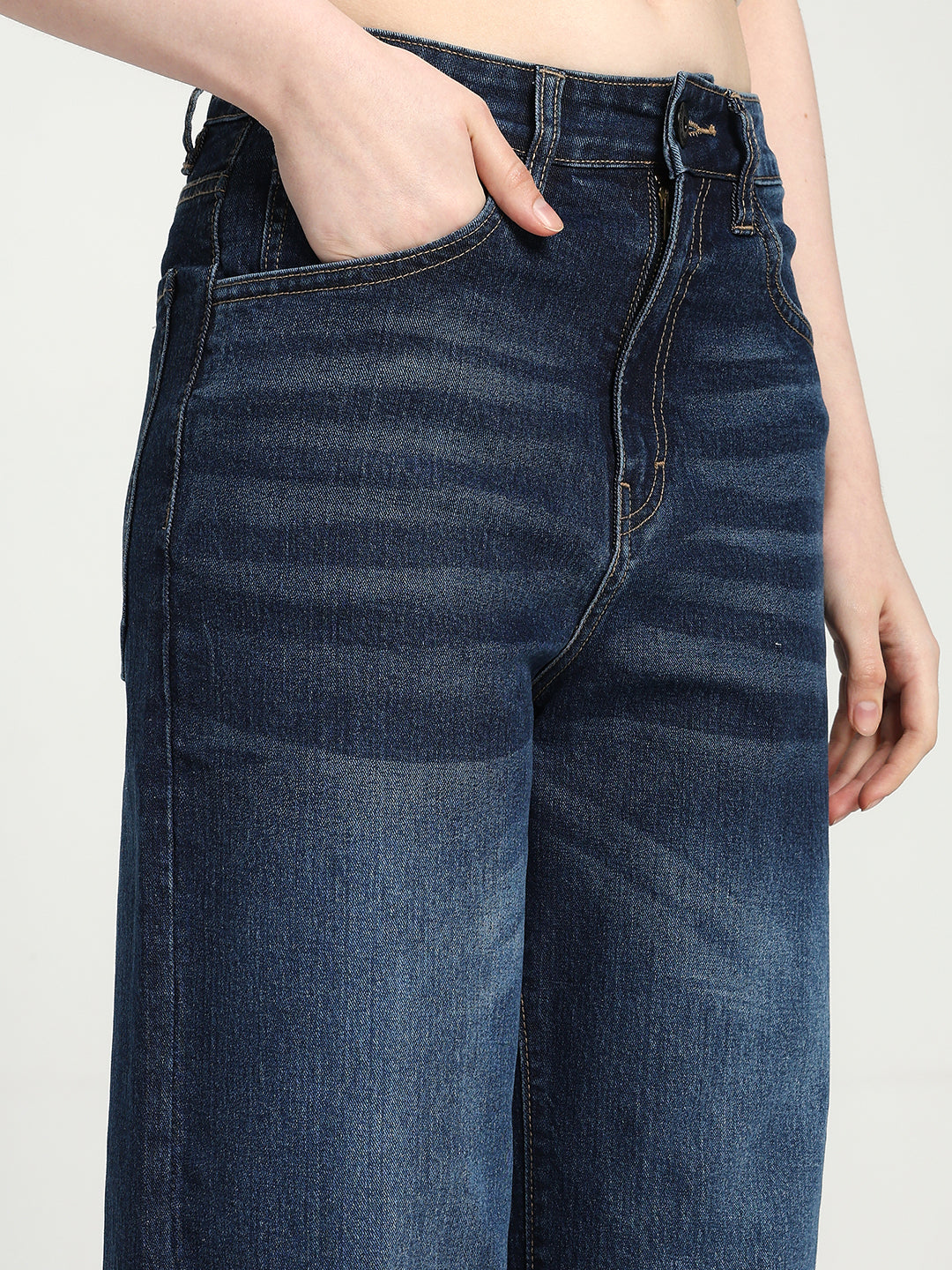 women wearing blue jeans on a plain background