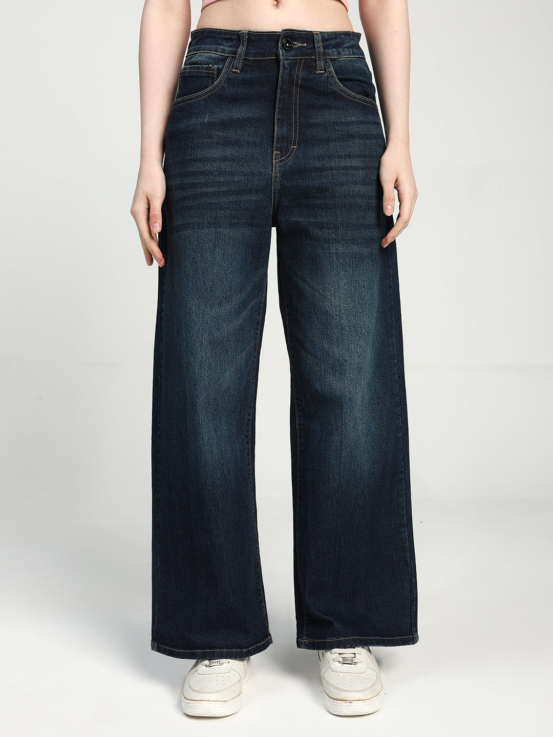 women wearing dark blue wide-leg jeans on a white background