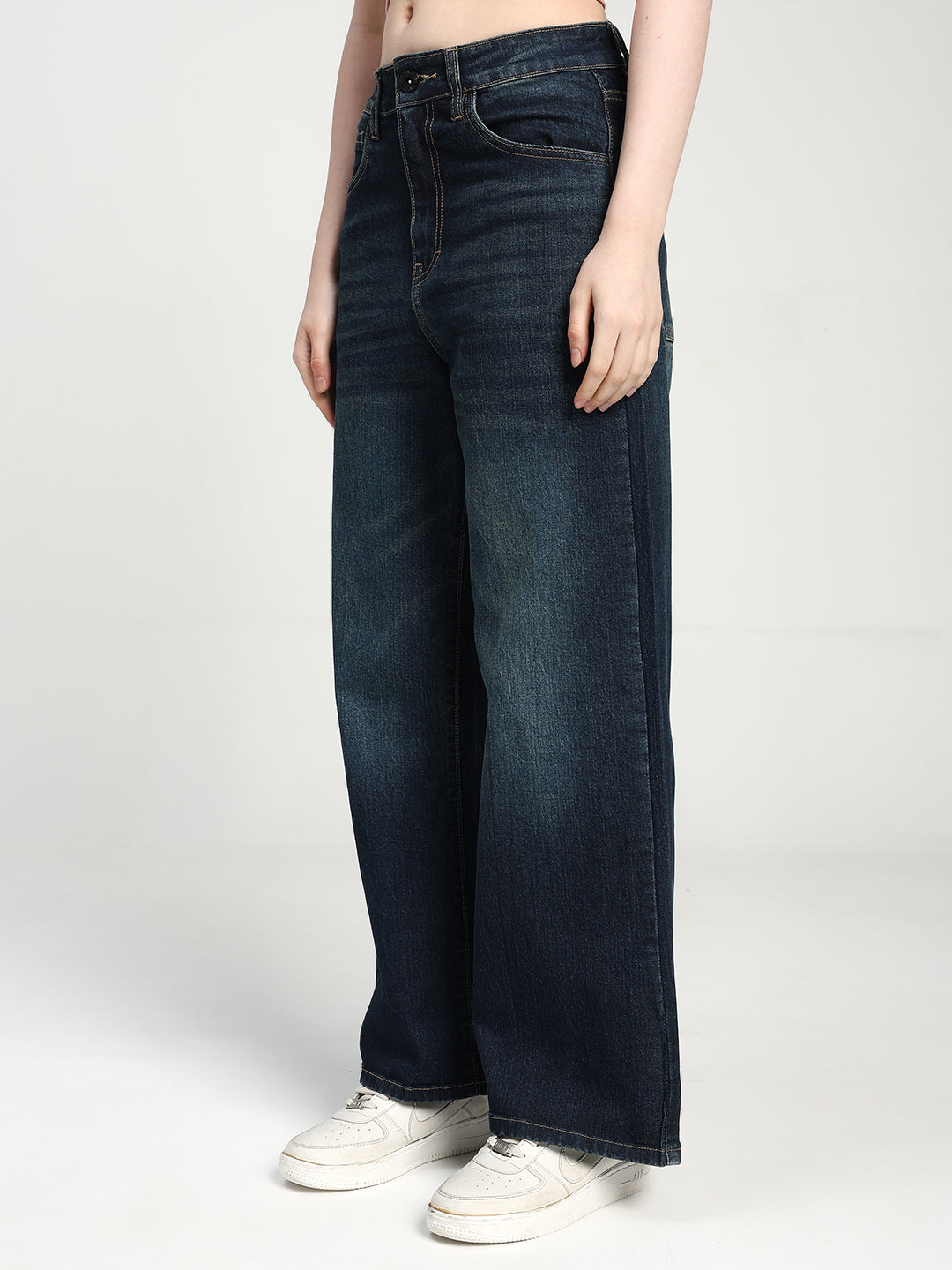 women wearing dark blue wide-leg jeans on a white background