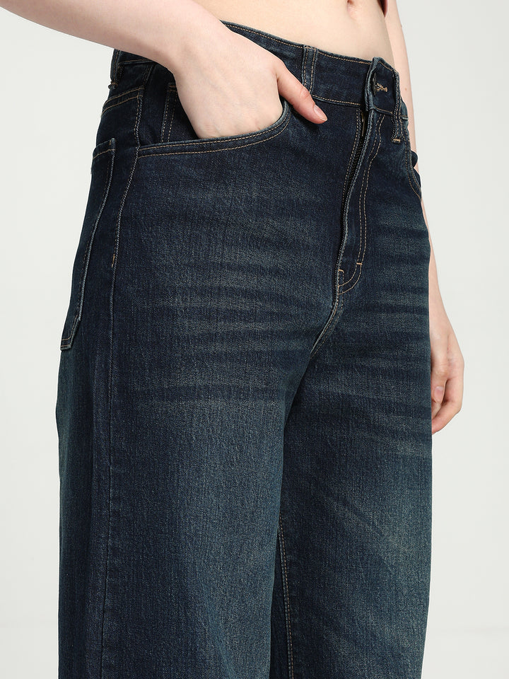 dark blue jeans worn by a women on a plain background