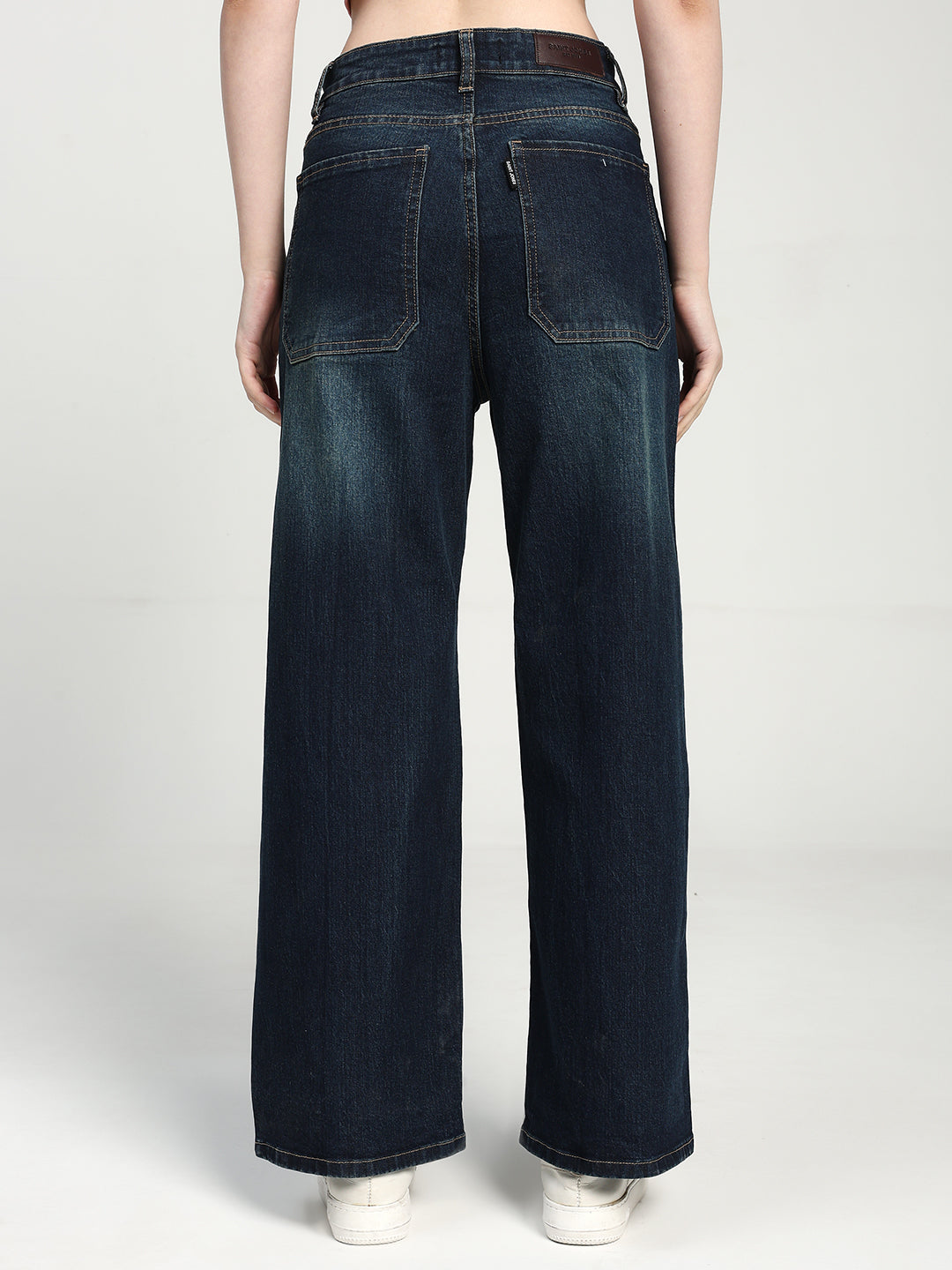 women wearing dak blue wide-leg jeans on a white background