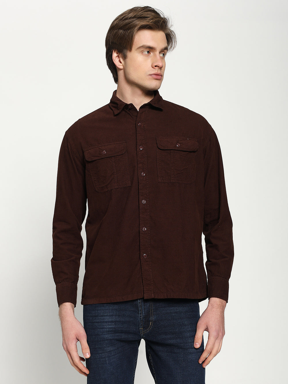 Man wearing a brown button-up shirt with two chest pockets on a white background