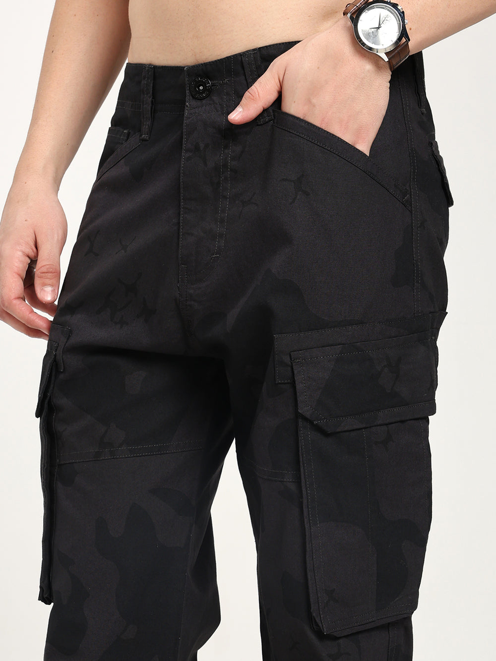 Black camouflage cargo pants worn by a man on a plain background