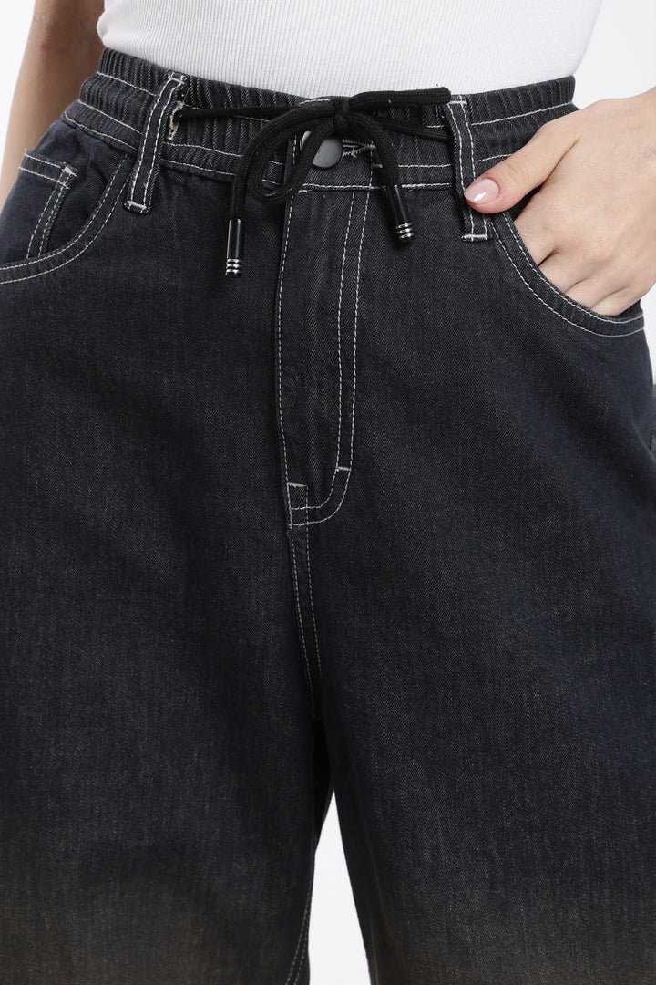dark vintage wash denim jogger with a drawstring waistband on a plain background