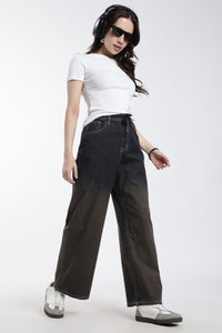 Woman wearing a white t-shirt, dark vintage wash wide-leg denim jogger, and headphones on a white background