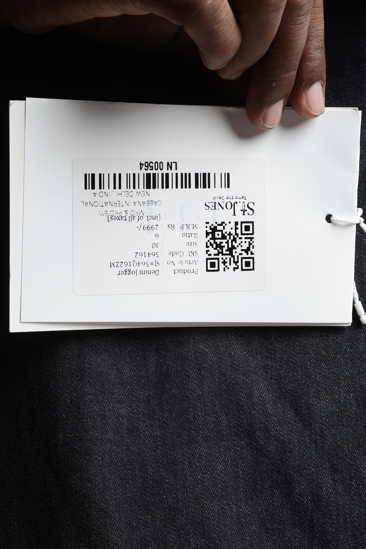 Hand holding a white card with text saint jones and QR code on a black background