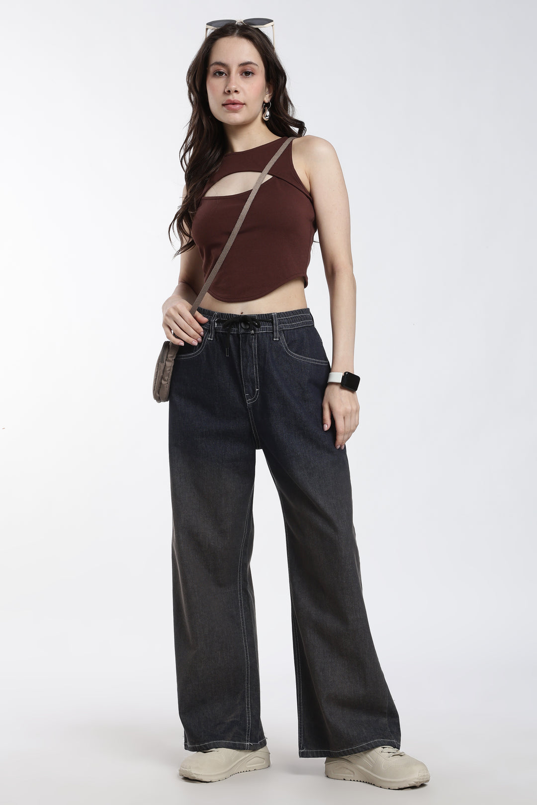 Woman wearing a brown top and vintage wash jogger on a white background